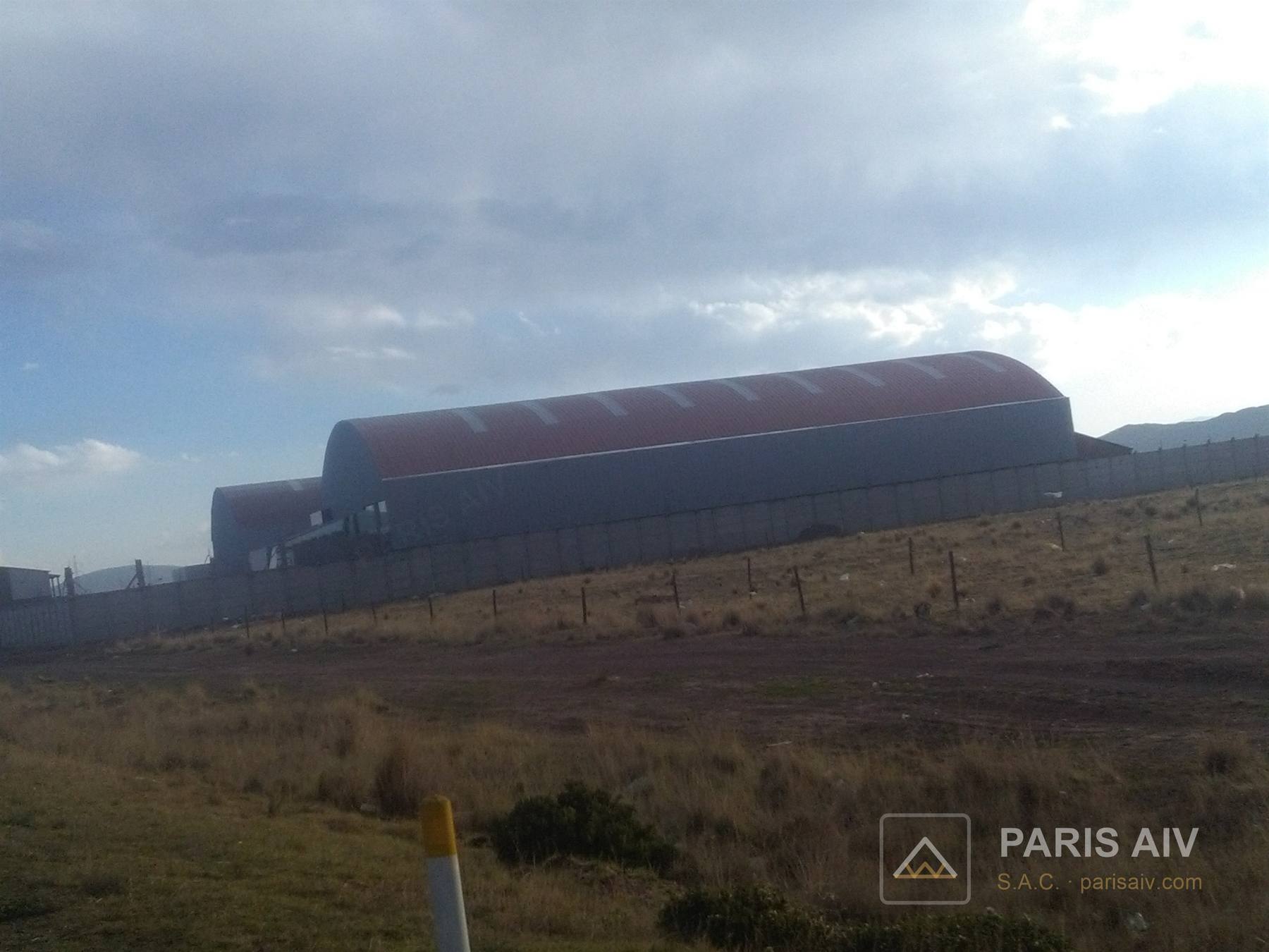Techo metálico curvo de color rojo en una ladera