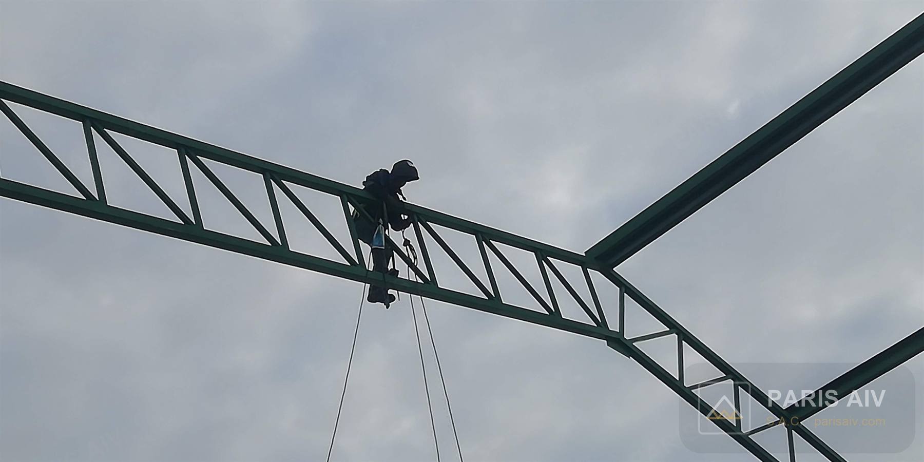 Trabajador montado sobre un tijeral verde