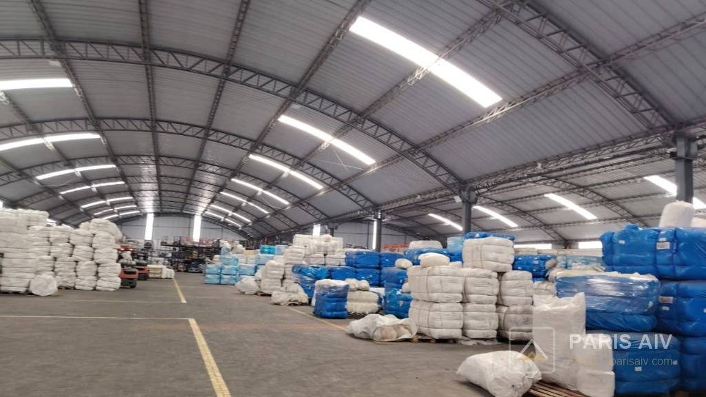 Nave en uso, con mercadería bajo una cubierta de cerchas